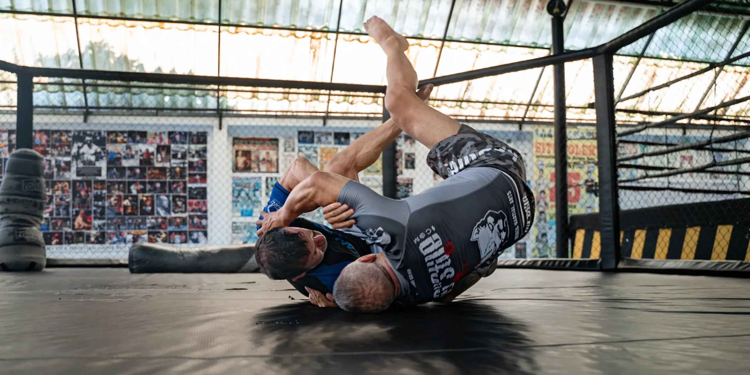 A BJJ practitioner executes an inverted guard, a complex and dynamic defensive position, against a training partner, highlighting the fluidity and flexibility required in Brazilian Jiu-Jitsu.