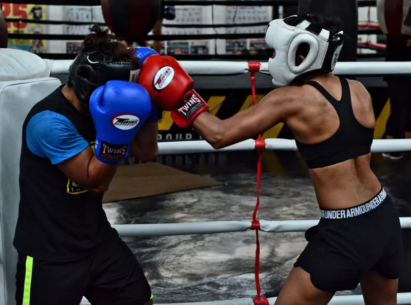 Girl sparring in boxing with headgear