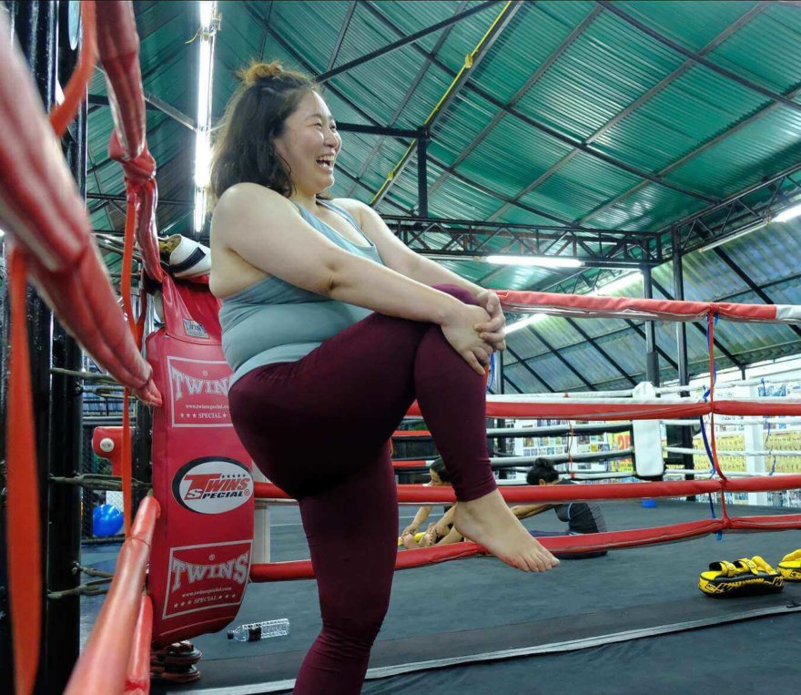 Donna felice fa stretching dopo una sessione di Muay Thai