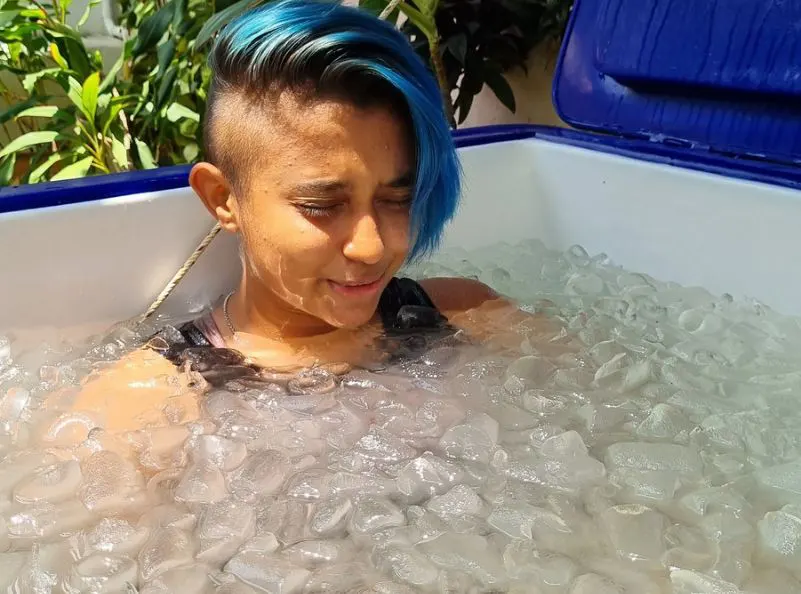 Young female fighter doing ice bath for recovery